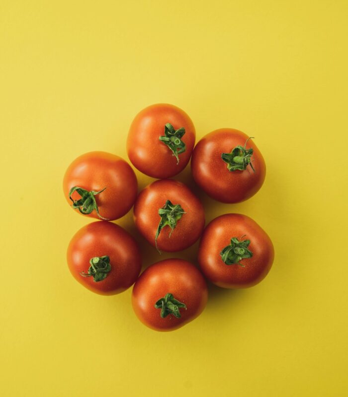 red tomato on yellow surface