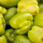 a pile of green peppers sitting next to each other