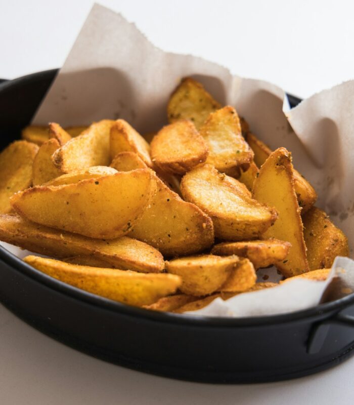 a black pan filled with potatoes on top of a table